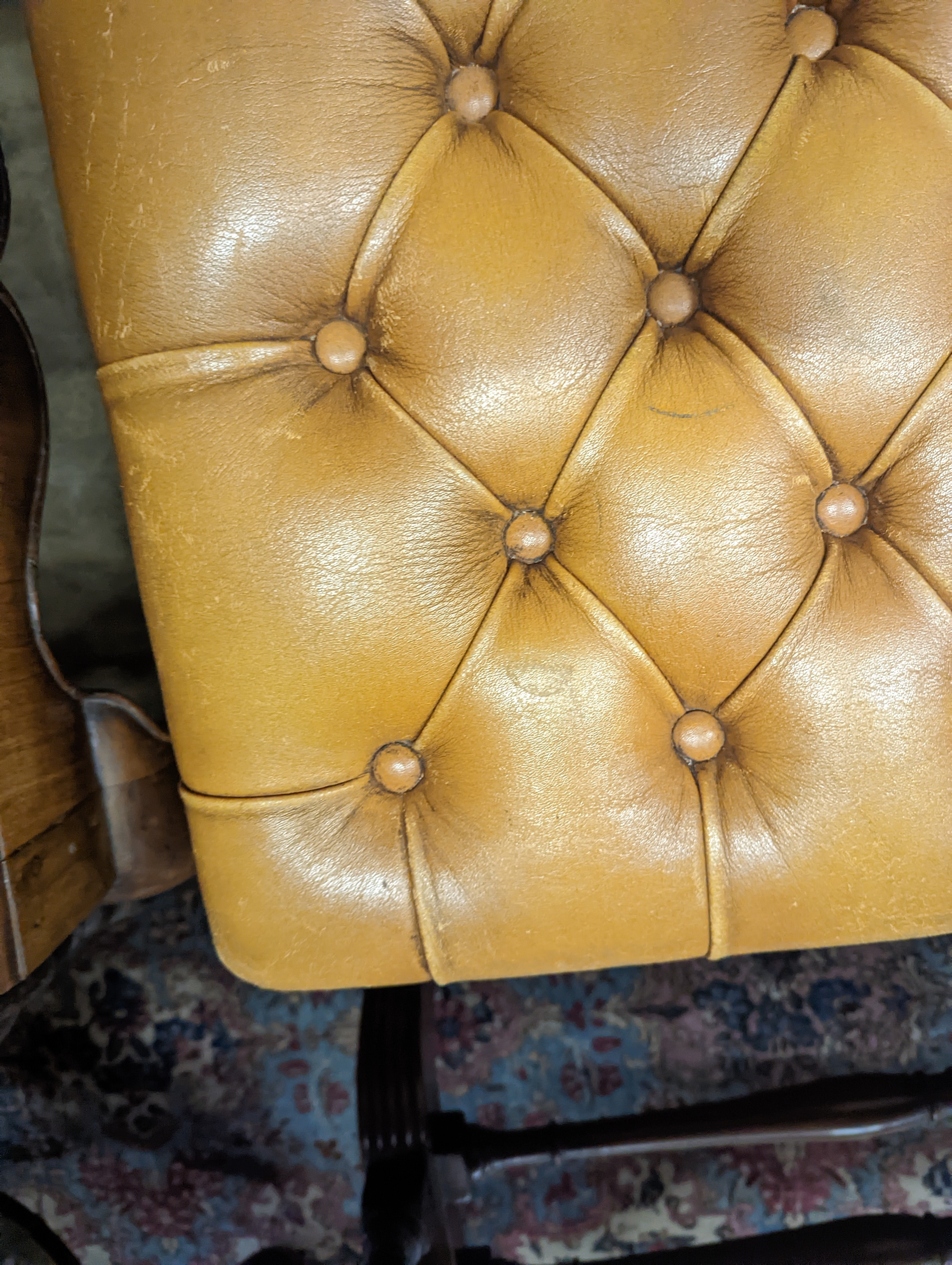 A Victorian carved X-framed rosewood footstool, upholstered in a buttoned brown leather, width 90cm depth 57cm height 42cm